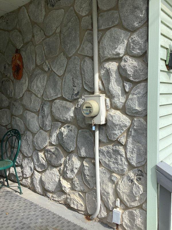 Conducted on-site evaluation for residential standby generator installation. Assessed existing electrical infrastructure including main service panel, meter location, and exterior mounting area on stone veneer facade. Documented current electrical panel configuration with dual column breaker arrangement and verified available capacity for generator integration. Identified optimal placement zone adjacent to utility meter on exterior wall for generator unit positioning and transfer switch installation.