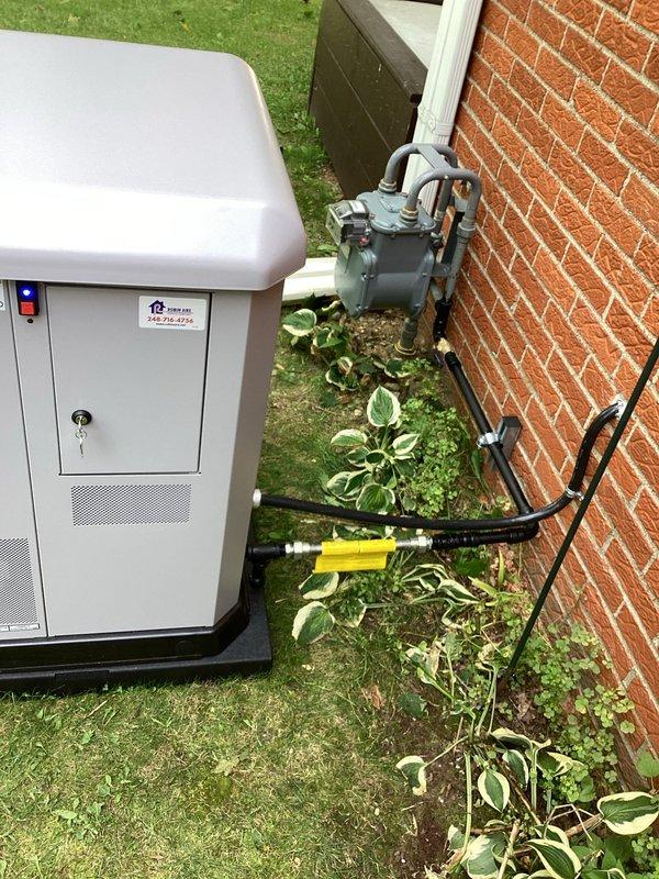Completed installation of Briggs & Stratton 13kW standby generator with 100-amp automatic transfer switch at residential property. Generator unit was mounted on concrete pad adjacent to building exterior with proper clearances, connected via electrical conduit and wiring routed along exterior wall to interior transfer switch panel installed in basement utility area. All connections were tested and system verified operational with status indicator lights functioning correctly.