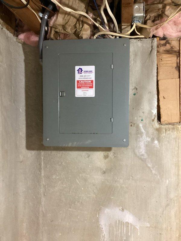 Completed installation of Briggs & Stratton 13kW standby generator with 100-amp automatic transfer switch at residential property. Generator unit was mounted on concrete pad adjacent to building exterior with proper clearances, connected via electrical conduit and wiring routed along exterior wall to interior transfer switch panel installed in basement utility area. All connections were tested and system verified operational with status indicator lights functioning correctly.