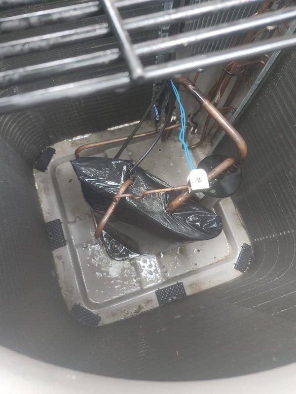 Completed scheduled AC maintenance inspection on residential cooling system. Inspected outdoor condenser unit and confirmed condenser coil fins are clean and undamaged with proper airflow clearance. Examined indoor evaporator coil assembly and drain pan, noting standing water present in condensate tray with visible copper refrigerant lines showing minor surface oxidation. Verified drain pan components and float switch are operational.