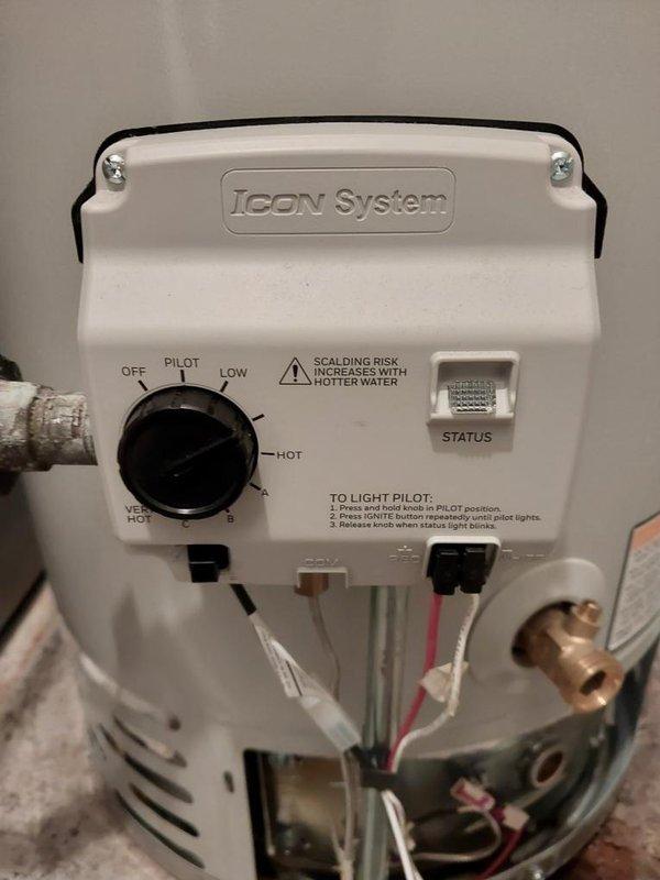 Responded to urgent no hot water call for 2-year-old residential water heater experiencing overheating and automatic shutdown cycles. Accessed unit in tight basement space behind furnace. Upon inspection, evaluated the ICON System gas control valve and thermostat assembly, examining the temperature control settings which were positioned between pilot, low, and hot settings. Assessed the gas control mechanism, pilot light operation, and associated wiring connections including the thermocouple and thermal safety devices. Inspected the aluminum flexible vent system and connections at top of unit to verify proper exhaust ventilation and draft. Checked for adequate combustion air supply in the confined installation area. Examined manufacturer specifications and safety labels on unit exterior. Evaluated the overall installation including gas line connections, temperature and pressure relief valve, and surrounding clearances given the restricted workspace adjacent to HVAC ductwork. Documented