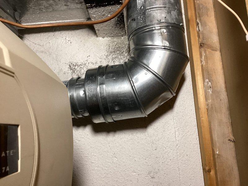Completed callback for water heater installation to address B-vent concerns. Verified proper installation of oval B-vent ductwork and elbow connections in attic space for Bradford White 50-gallon natural gas water heater (Model RG250T6N, 40,000 BTU/hr input). Inspected all vent connections, confirmed proper sealing and secure mounting of galvanized ductwork, and documented installation with photographs showing compliant venting system and unit specifications.