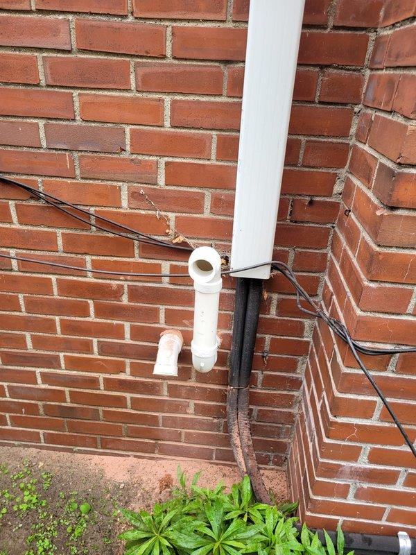 Completed installation of Lennox furnace system in basement utility room, including proper mounting of air handler unit against prepared wall surface. Installed condensate drainage system with white PVC piping routed vertically through interior space and exterior wall, terminating with appropriate elbow fitting on building exterior, and connected condensate pump with dedicated electrical supply to ensure proper moisture removal from system.