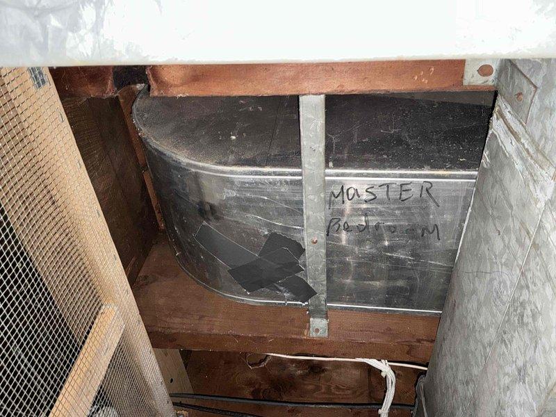 Conducted assessment of mechanical room containing water heater tank (labeled "MASTER BATHROOM") mounted on wooden structural framing in crawlspace area. Inspected surrounding environment for potential ductwork installation requirements, noting current structure conditions and clearances for future HVAC system integration.