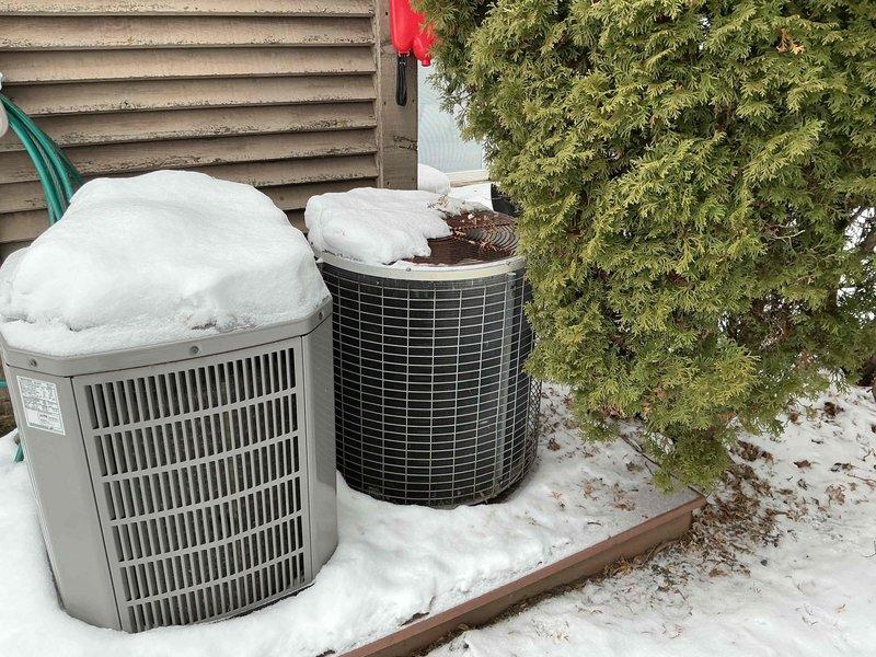 Completed comprehensive inspection of existing HVAC system including indoor air handler/furnace unit in mechanical room and outdoor heat pump/condenser units. Snow accumulation was observed on outdoor equipment, particularly heavy on one unit. Recommended full system replacement due to visible aging components, deteriorating ductwork connections, and equipment inefficiency evidenced by condition assessment.