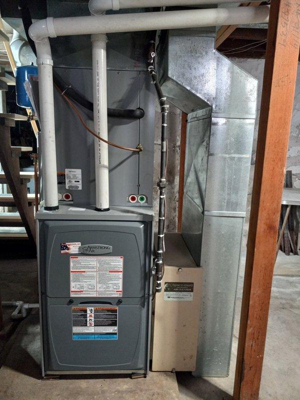 Inspected Armstrong furnace system in basement utility area. Evaluated PVC venting/condensate lines and connection to existing ductwork. Noted wall surface deterioration near plumbing installation that may require attention to prevent moisture-related issues affecting HVAC system performance.