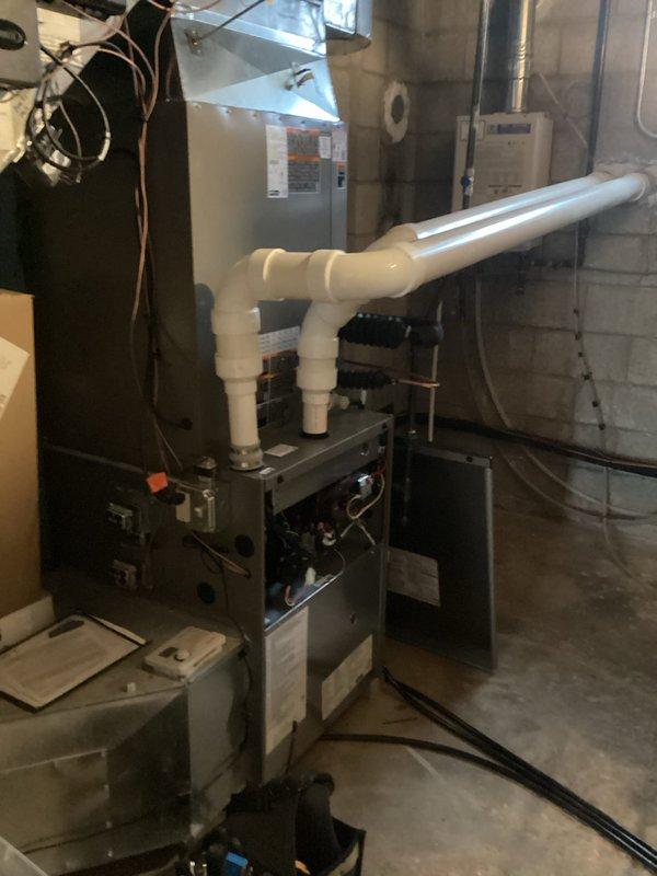 Responded to call back regarding newly installed HVAC system. Inspected Goodman furnace unit in basement utility room and identified improper condensate drain pipe installation. Corrected PVC drain pipe configuration, eliminating improper elbow joints that were causing water backup. Verified all electrical connections and refrigerant lines were properly secured. System now operating within manufacturer specifications with proper drainage.