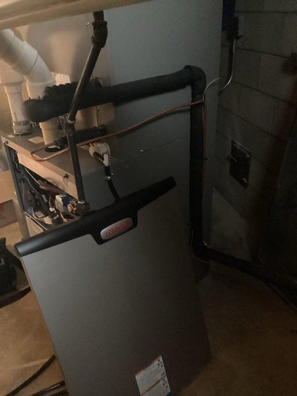 Responded to call back regarding newly installed HVAC system. Inspected Goodman furnace unit in basement utility room and identified improper condensate drain pipe installation. Corrected PVC drain pipe configuration, eliminating improper elbow joints that were causing water backup. Verified all electrical connections and refrigerant lines were properly secured. System now operating within manufacturer specifications with proper drainage.