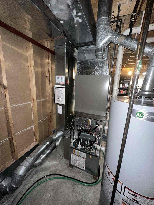 Conducted comprehensive inspection of existing HVAC system in basement utility area, focusing on furnace/air handler unit showing signs of deterioration. Documentation included detailed assessment of the aging central unit, connected ductwork system, and integration with existing water heater. Recommended full system replacement based on observed wear of internal components, control systems, and outdated specification parameters.