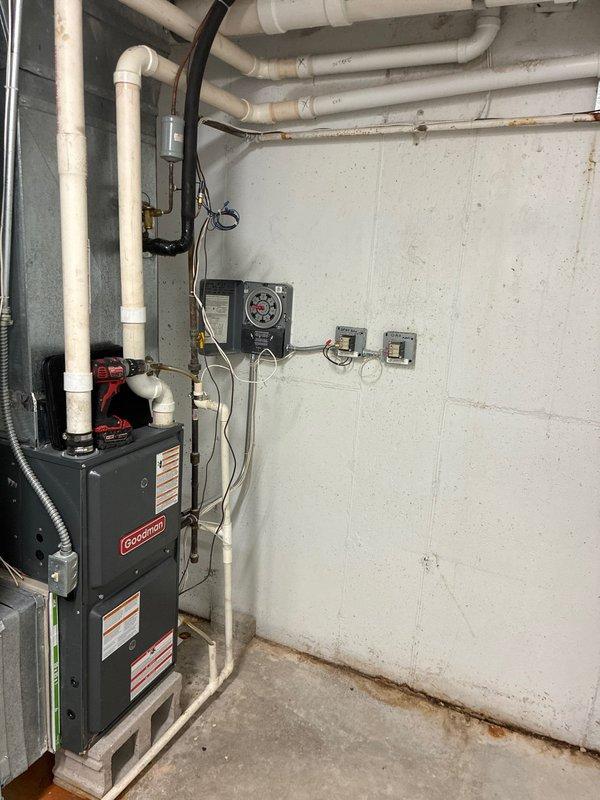 Conducted comprehensive IAQ assessment in commercial facility, focusing on Goodman heating unit and associated ductwork system. Identified areas of compromised insulation on primary ventilation ducts requiring remediation. Documented junction box connections and control systems for further evaluation. Photos captured existing installation configuration including utility room equipment placement and ceiling-mounted air handler with foil-wrapped ductwork.