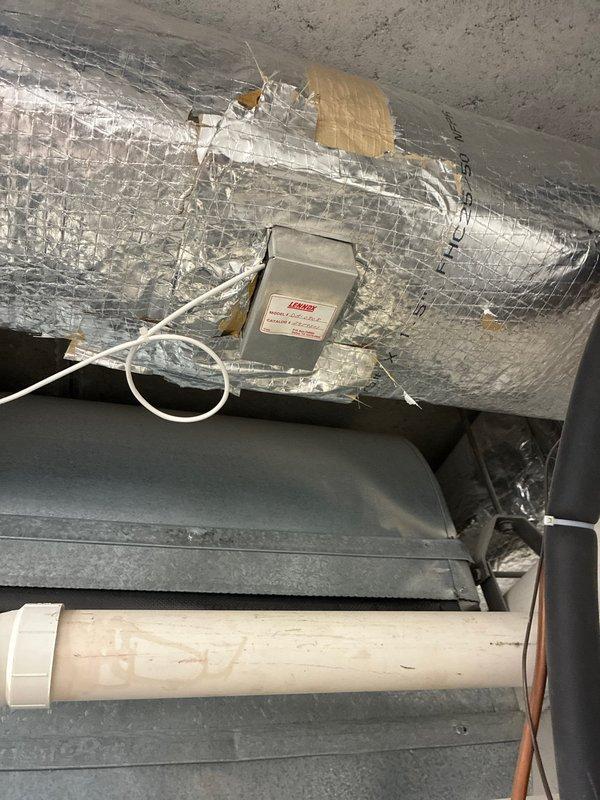 Conducted comprehensive IAQ assessment in commercial facility, focusing on Goodman heating unit and associated ductwork system. Identified areas of compromised insulation on primary ventilation ducts requiring remediation. Documented junction box connections and control systems for further evaluation. Photos captured existing installation configuration including utility room equipment placement and ceiling-mounted air handler with foil-wrapped ductwork.