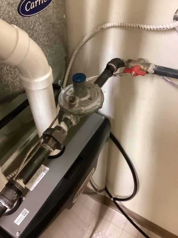 Completed installation of furnace with proper gas regulator setup and plumbing connections. Installed new pressure valve with associated black metal gas piping and PVC drainage system. Ensured proper cable routing along fixture edge with secure connections to electrical control unit.