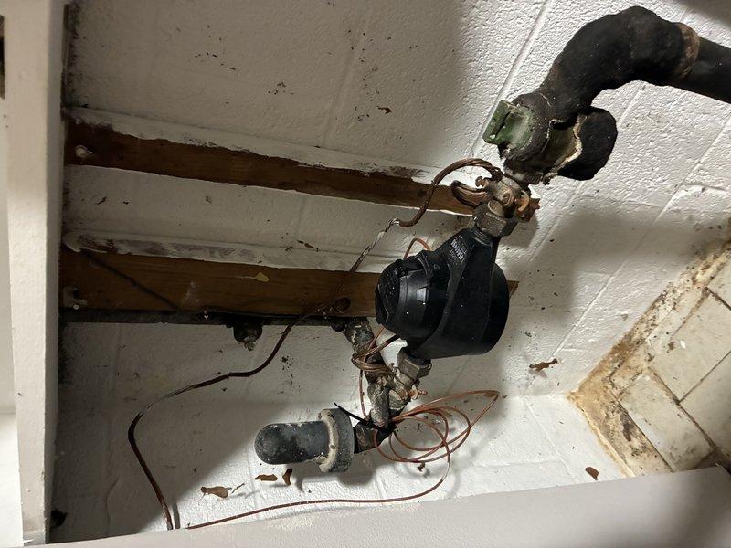 Responded to service call for water leakage. Inspected aged plumbing system with visible corrosion at connection points between black pipe assembly and copper pipes. Replaced damaged section of main pipe and deteriorated fittings in ceiling/wall space. Pressure tested system after repair to confirm successful resolution of the leak.