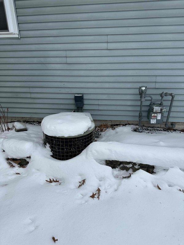 Conducted site evaluation for HVAC replacement at residential property. Current system shows age-related deterioration with insufficient insulation on existing ductwork in basement mechanical room. Exterior assessment revealed snow-covered condenser unit with protective cage that will require replacement. Recommended full system replacement including new energy-efficient air handler, properly insulated ductwork, and appropriately sized condenser unit with modern refrigerant standards.