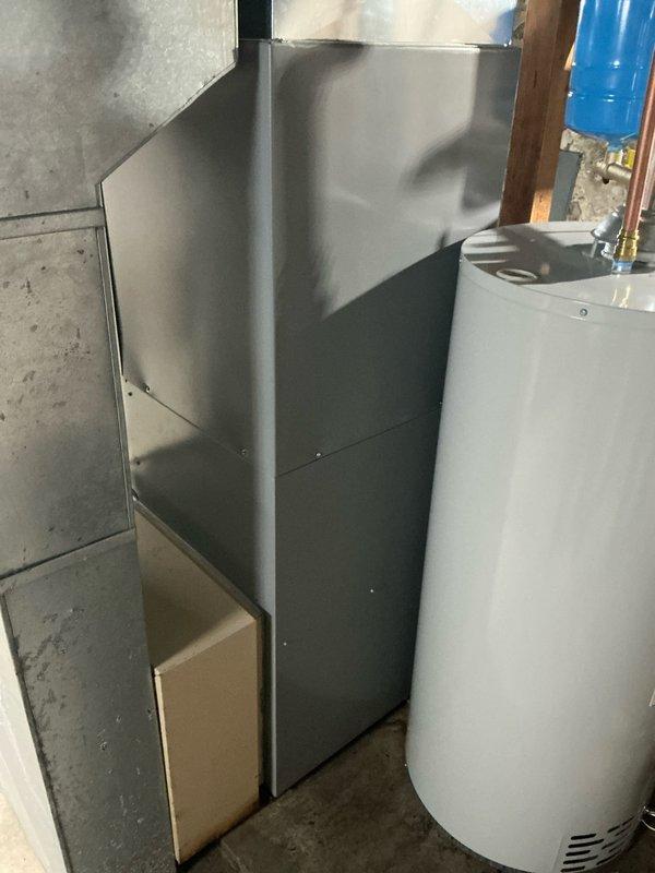 Completed comprehensive inspection of existing HVAC system in basement utility area, documenting deteriorating foundation walls with visible moisture damage. Captured photographic evidence of current furnace installation adjacent to water heater, noting space constraints and necessary considerations for equipment replacement. Prepared estimate for full system replacement due to age and condition of current unit.