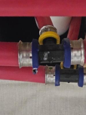 Inspected plumbing valves and connections in a mechanical system. Documented hot and cold water supply lines with proper labeling ("H" and "C" markings). Observed brass valve fittings and corrugated supply hose, noting some tarnishing on metal components. Visual inspection confirmed all components were properly installed and functioning as intended.