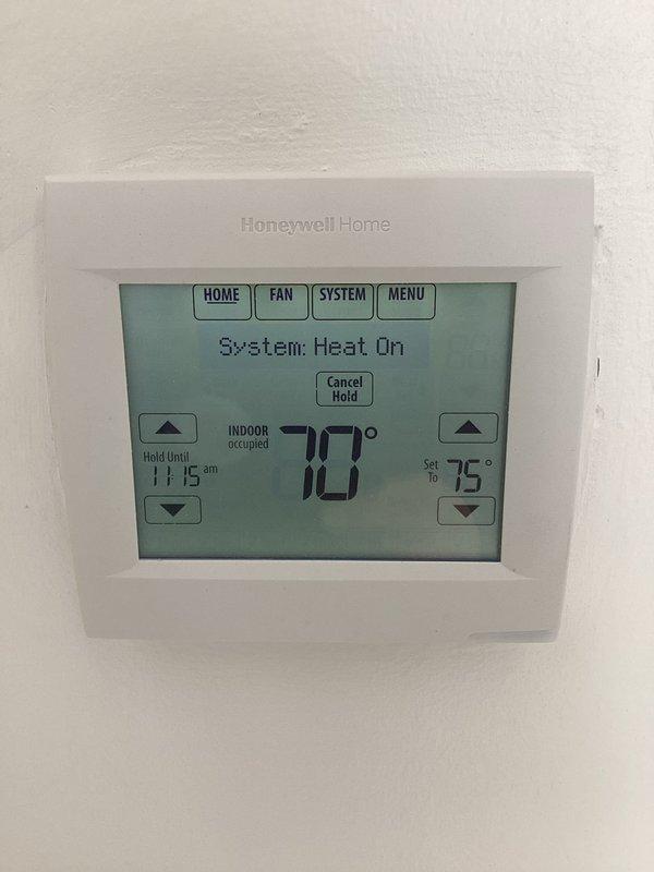 Completed installation of a new Honeywell Home digital thermostat. Mounted unit securely on wall, configured system settings for heating functionality, and verified proper operation with successful temperature display and control functions. System is now operating correctly in heat mode with appropriate temperature regulation.