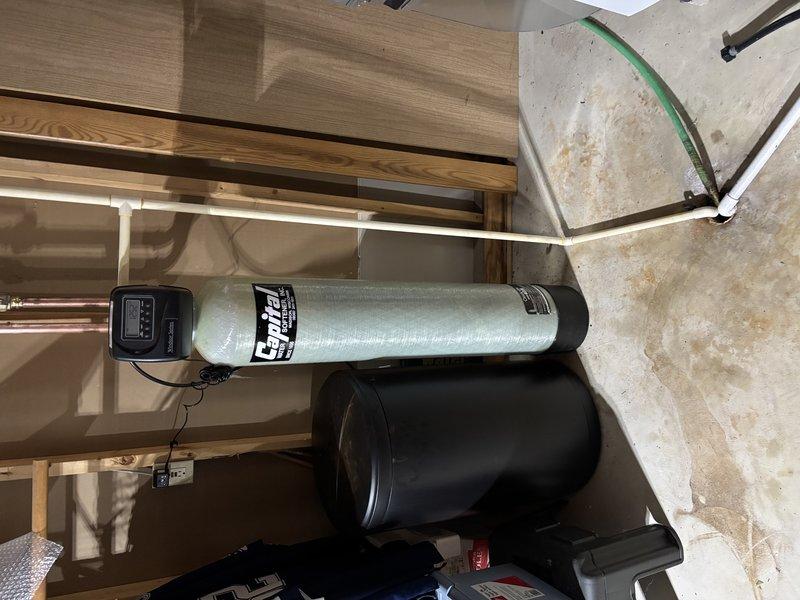 Successfully installed an Envirotec water filtration/softening system in the utility area, including the main cylindrical tank with digital control panel and secondary brine tank. Completed all necessary plumbing connections with both copper and PVC piping, ensuring proper integration with the home's existing water system.