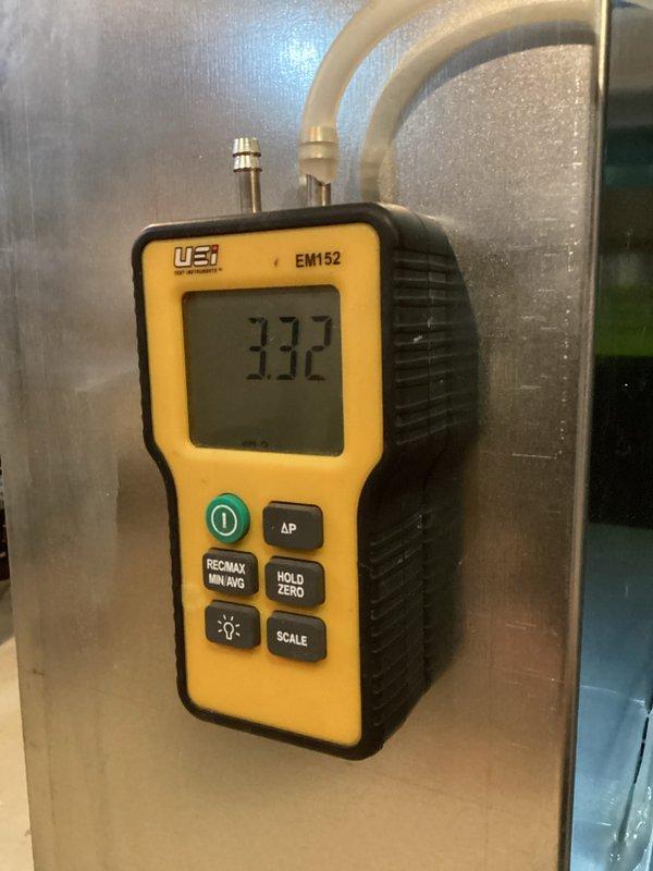 Installed new Carrier furnace unit with properly connected galvanized ductwork and PVC venting system. System tested with UEi EM152 manometer showing 3.32" WC gas pressure, confirming proper operational parameters. Installation completed with all connections secure and system functioning according to manufacturer specifications.