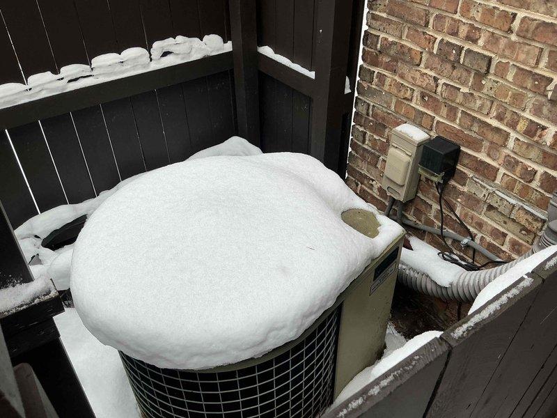 Completed inspection of commercial HVAC system with focus on ductwork configuration and outdoor condenser unit. Documented extensive snow accumulation completely covering the outdoor unit positioned against brick wall, potentially compromising proper airflow and operation. Recommended replacement of system to ensure reliable operation and prevent future service disruptions during severe winter conditions.