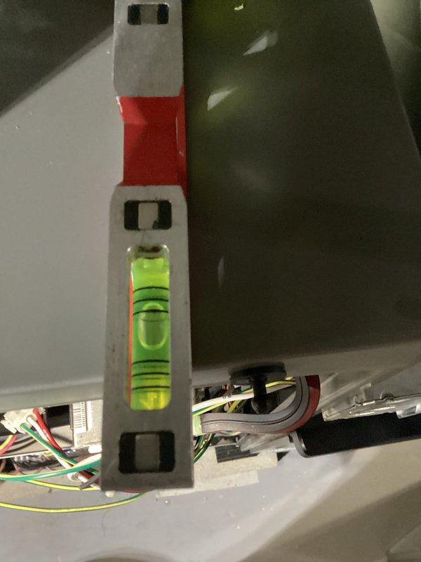 Conducted routine HVAC tune-up in unfinished basement utility area. Inspected exposed ductwork and ventilation system running between wooden joists. Verified system installation is properly leveled using precision measuring tools, with particular attention to electrical connections and component alignment.