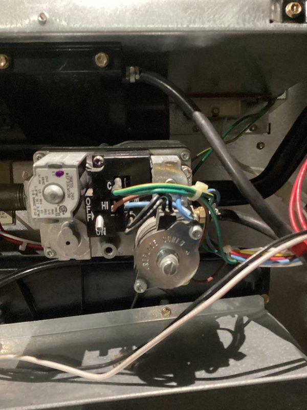 Performed routine tune-up on HVAC system, inspecting control valve assembly and ECM motor. Verified all electrical connections were secure on the control panel where multiple wires (green, blue, red, white) connect to terminals. ECM motor was in good working condition with no signs of wear or damage; all wiring connections to the motor were intact and properly seated.