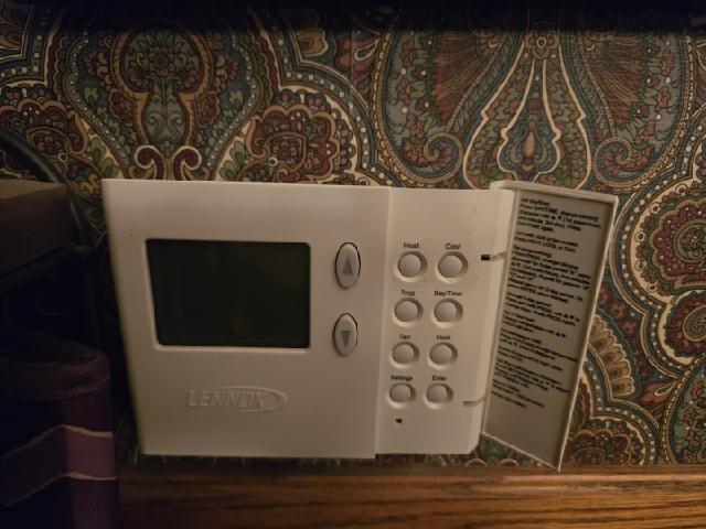 Inspected non-operational thermostat on an aging Lennox HVAC system. Found display was blank with no power. Replaced faulty thermostat batteries, tested system cycling through heat mode, and verified proper operation. Instructed customer on basic thermostat programming using the manual.