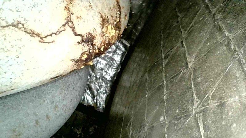 Performed scheduled tune-up on aging HVAC system located in confined utility area. Observed significant rust and water damage on unit components including visible corrosion on piping and metal ducting. Documented deterioration with photos for record, particularly noting stress lines and potential cracking that may require future attention.