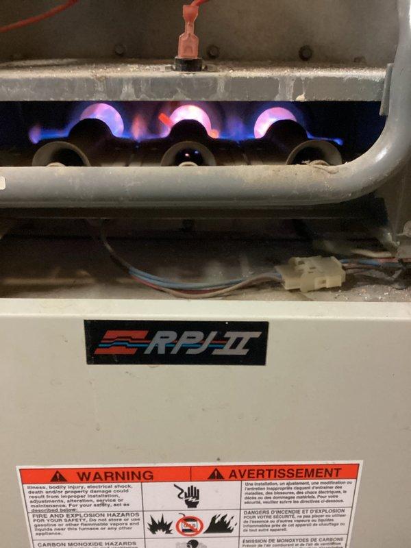 Responded to no-heat call for aging RPJ-II furnace. Visual inspection revealed dust accumulation and wear on multiple components. Diagnosed failed ignition sequence due to dirty burners and faulty gas valve assembly. Cleaned burner assembly, replaced gas valve, and confirmed proper flame characteristics after repair. Unit now operating normally with successful ignition and adequate heat output.