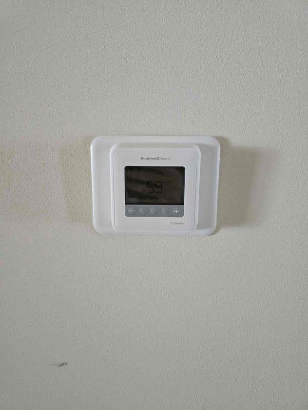 Successfully installed a complete HVAC system featuring a Honeywell Home digital thermostat with temperature control functionality. System installation included proper mounting of equipment cabinet with secure copper line connections and appropriate fastening to ensure optimal system performance.