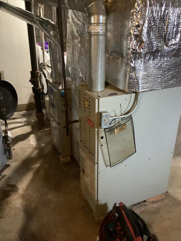 Responded to a no-heat call for a residential system with an aging furnace (10+ years). Upon inspection of the unit located in the basement, found the flame sensor covered with carbon deposits causing intermittent flame failure. Cleaned the flame sensor thoroughly, tested ignition sequence, and verified proper operation through multiple heating cycles. System is now functioning normally with consistent flame detection and proper heat output.