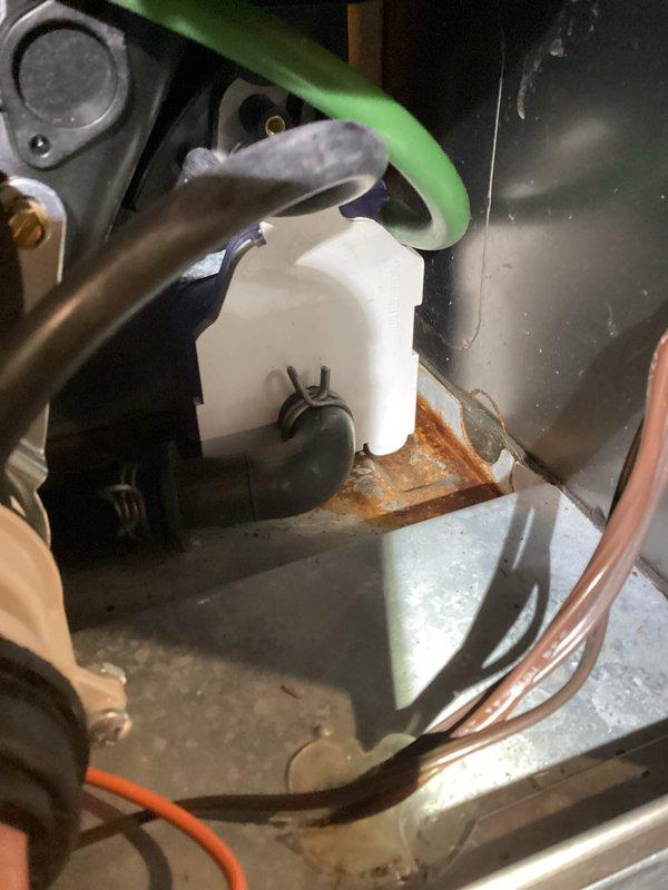 Performed inspection of furnace system revealing corrosion on drain pan and condensate components. Documented evidence of rust formation on metal housing near drainage assembly. Examined control board, electrical connections, and heat exchanger - all operational with no visible damage. Captured detailed photos of interior components for warranty documentation.