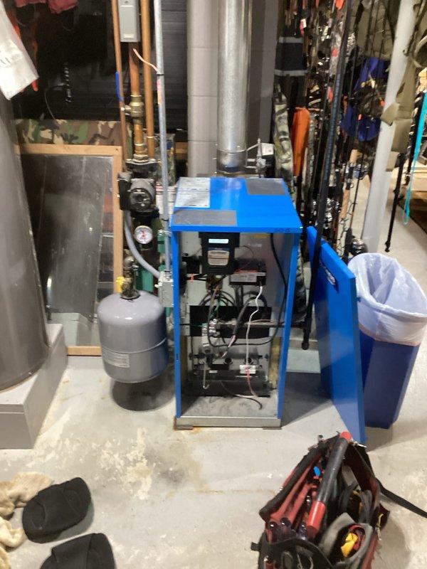 Completed service on a residential boiler system in basement utility room. Inspected internal components including wiring and mechanical parts, and checked operation of associated expansion tank and gas cylinder. System appears in good working condition with no visible damage or operational issues detected.