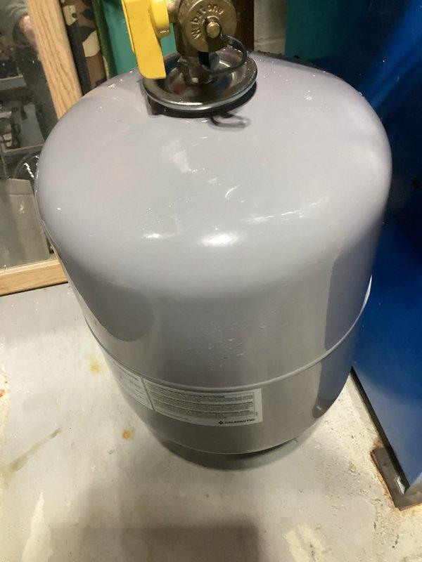 Completed service on a residential boiler system in basement utility room. Inspected internal components including wiring and mechanical parts, and checked operation of associated expansion tank and gas cylinder. System appears in good working condition with no visible damage or operational issues detected.