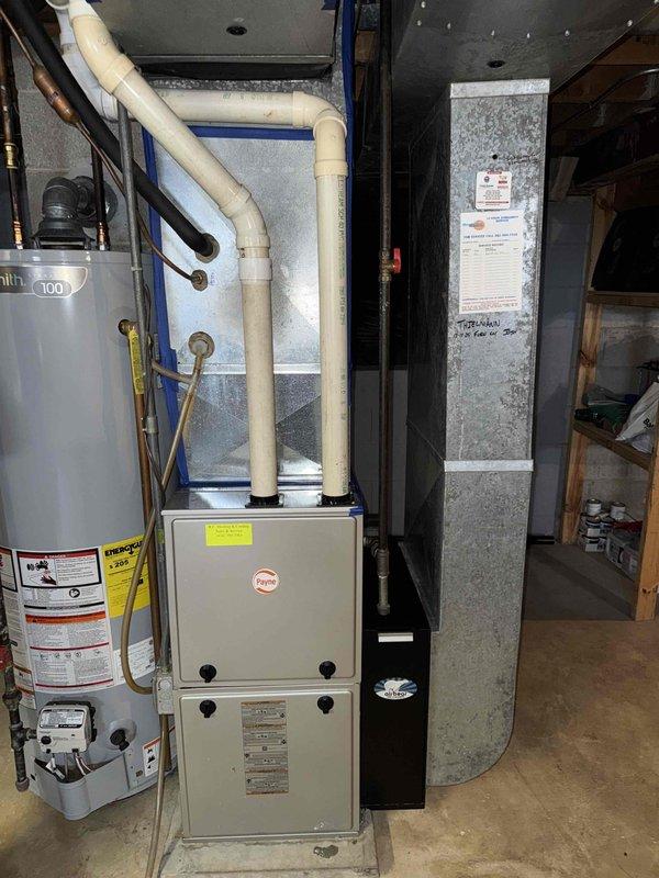 Completed routine maintenance on Payne furnace system in residential basement. Identified significant rust and corrosion on interior components, particularly around the heat exchanger connection ports. Documented water heater condition (Bradford White model 100) for future reference as it appears to be approaching end of service life.