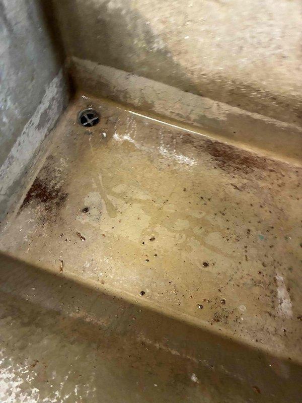Responded to no heat complaint on unit less than 10 years old. Inspected system and found condensate drain basin significantly clogged with debris, causing water backup. Cleaned drain and confirmed proper operation of condensate removal system. Unit returned to normal functioning after service.