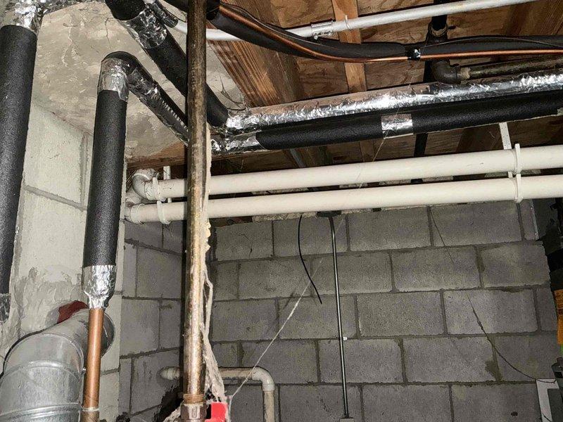 Inspected existing Carrier HVAC system in basement utility area. Evaluated current ductwork configuration, including metal ducts with foil insulation and PVC ventilation components. Documentation photos taken of the unit installation and surrounding mechanical infrastructure to prepare comprehensive replacement estimate.