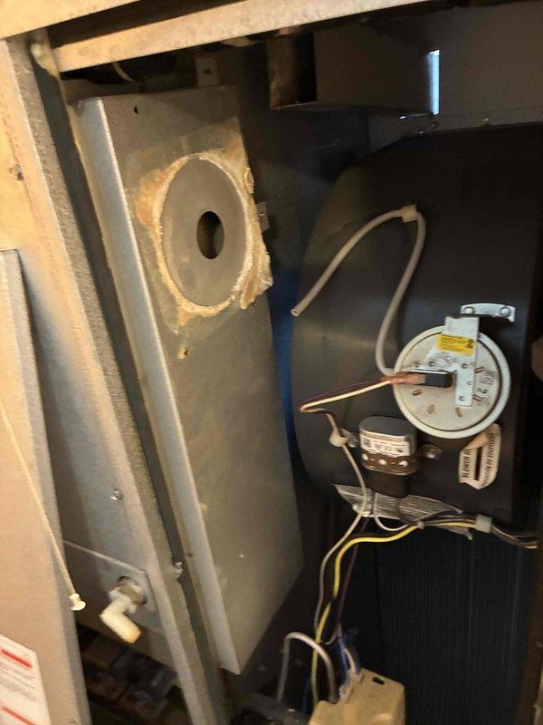 Inspected furnace for no heat complaint and found pressure switch faulty. Removed access panel to check internal components, revealing normal blower motor assembly but defective pressure switch preventing proper system ignition. Replaced pressure switch, tested system, and verified proper heating operation before closing unit.