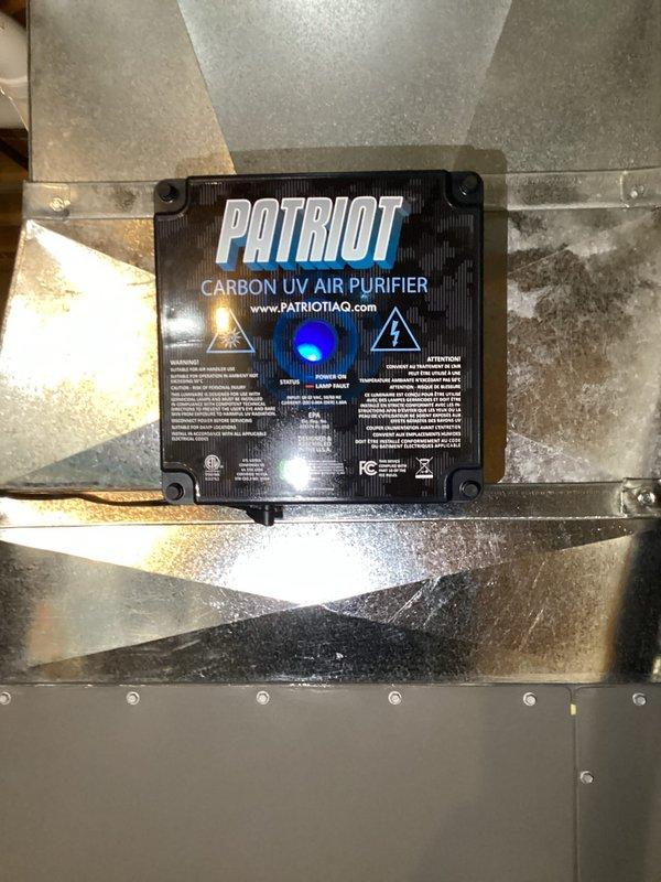 Completed installation of a Patriot Carbon UV Air Purifier in the existing HVAC system. Unit was properly mounted to ductwork with secure fasteners and electrical connections were established via the prepared junction box on the concrete floor. System was tested and confirmed operational as indicated by the illuminated blue indicator light.