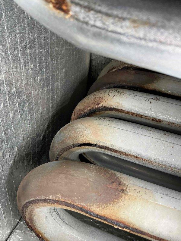 Performed scheduled tune-up service on unit and discovered significant corrosion and oxidation on evaporator coils. Inspection revealed extensive rust formation on copper tubing, particularly at the bends, indicating advanced deterioration of the heat exchange components. Recommend scheduling full system evaluation as the current condition may affect system efficiency and longevity.