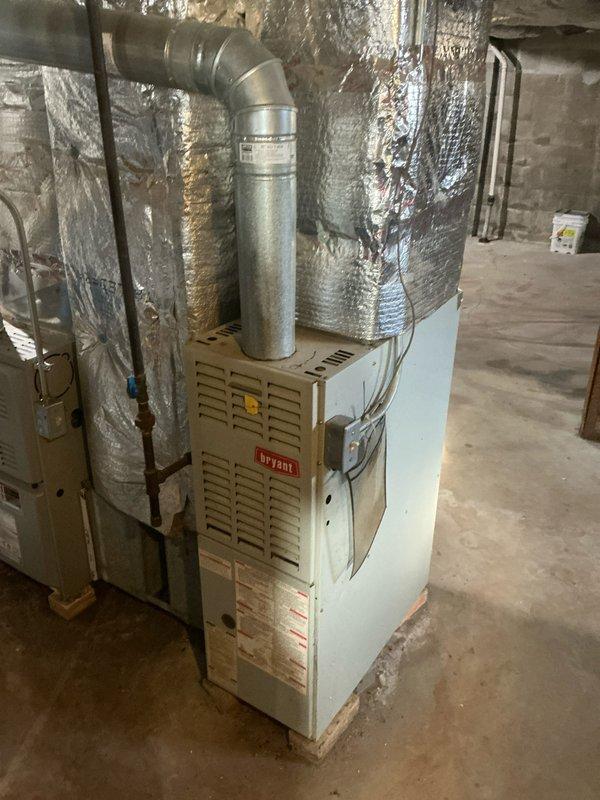 Conducted assessment of existing Bryant furnace system located in basement utility area. Evaluated current installation including primary heating unit, associated ductwork with galvanized metal elbow pipe, and reflective insulation materials. Documented condition of system components to develop appropriate replacement specifications.