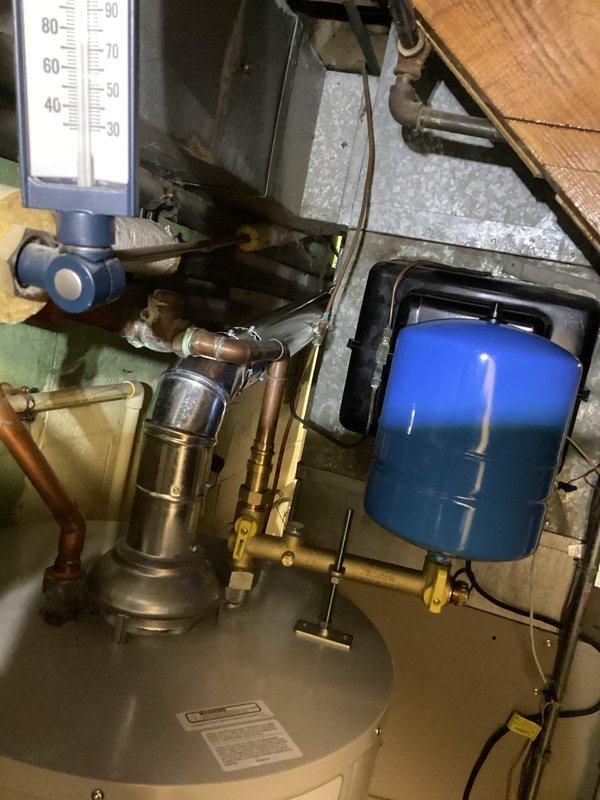 Installed a complete residential hot water system including a Bradford White water heater with proper venting, copper supply lines, and PVC drain connections. System includes a wall-mounted blue expansion tank with appropriate valves, thermometer, and brass fittings to ensure optimal pressure regulation and temperature control.