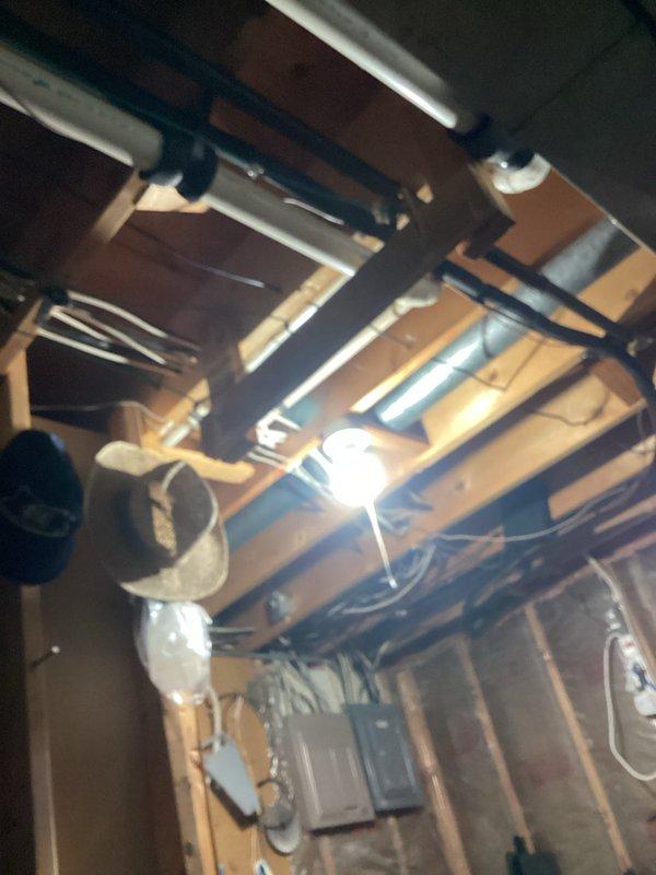 Performed comprehensive tune-up service on basement HVAC system, inspecting all visible plumbing connections and drainage pipes. Examined ceiling-mounted ductwork, checked light fixture operation, and verified proper insulation around mechanical components.