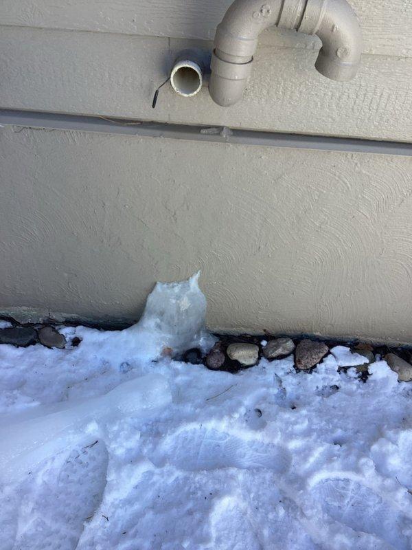 Conducted warranty service inspection of HVAC system, which included examination and documentation of air filtration components showing accumulation of particulate matter on the filter frame. Additionally, inspected and photographed exterior condensate drainage system, noting proper PVC elbow installation and confirming drainage path through foundation gravel, though observed some ice formation at discharge point that should be monitored during freezing conditions.