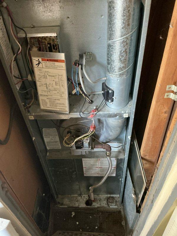 Conducted visual inspection of existing HVAC system located in utility closet. Older furnace unit showed normal wear with visible dust accumulation and minor corrosion on metal components. Inspected electrical connections and ductwork for replacement evaluation. Recommended full system replacement due to age-related deterioration and to improve efficiency.