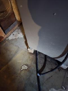 Conducted inspection of furnace unit located in basement utility area. Observed unit placement against unfinished wall with exposed wooden studs. Noted visible moisture staining on concrete floor surrounding equipment that requires monitoring. All connections and tubing appear intact with no immediate service requirements identified.