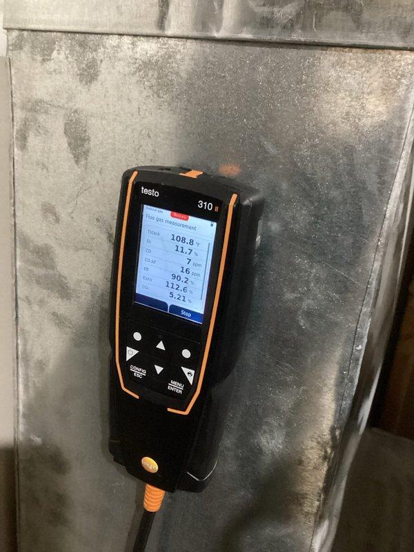 Performed routine tune-up of heating system including combustion analysis with Testo 310 II analyzer showing acceptable readings. Conducted inspection of furnace internals with front panel removed, checked electrical connections and verified proper operation of blower motor assembly. Connected diagnostic tool to evaluate system parameters and ensure all components functioning within specifications.