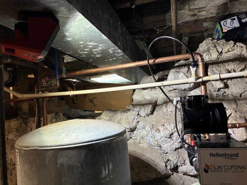 Responded to callback for copper pipe installation with Iron Curtain 2.0 filtration system. Inspected existing plumbing infrastructure in basement area, including copper supply lines, PVC drainage pipes, and Hellenbrand water treatment system. Confirmed proper installation and connections of all components; system functioning as designed.