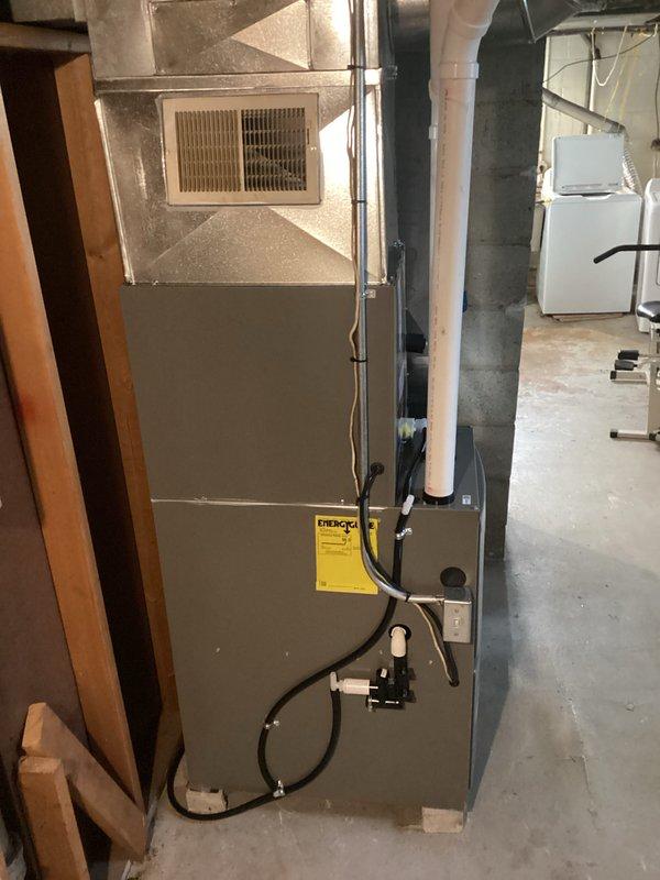 Completed full HVAC system installation including new furnace with energy-efficient rating as evidenced by yellow efficiency label. Installation included proper connection of all ductwork, electrical components, condensate drainage via PVC piping, and integration with water heater system featuring copper piping and expansion tank. All components tested and verified to be in proper working condition.