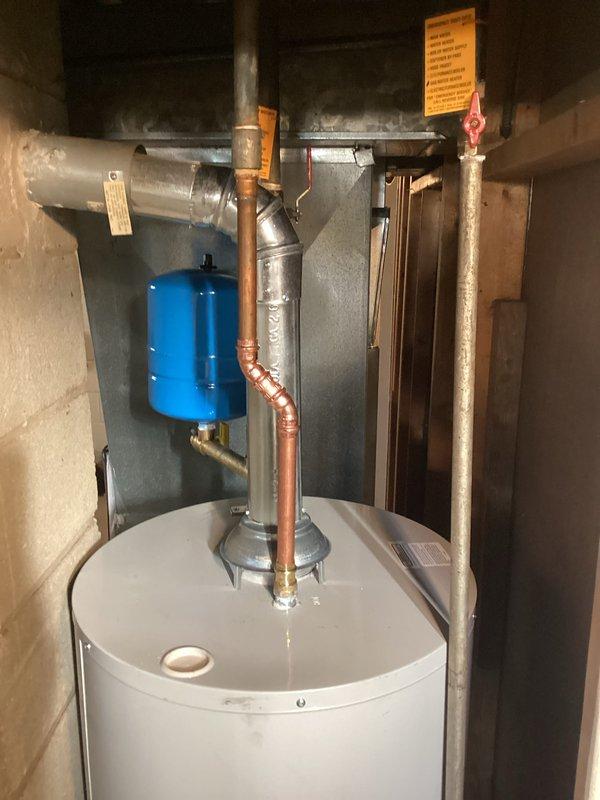 Completed full HVAC system installation including new furnace with energy-efficient rating as evidenced by yellow efficiency label. Installation included proper connection of all ductwork, electrical components, condensate drainage via PVC piping, and integration with water heater system featuring copper piping and expansion tank. All components tested and verified to be in proper working condition.